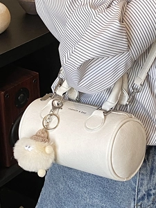 White cylinder handbag with FASHION & BAG print and a cute plush lamb charm