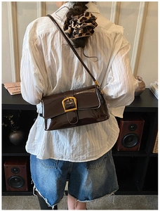 Detailansicht der dunkelbraunen Lackleder-Schultertasche mit goldener Metallschnalle