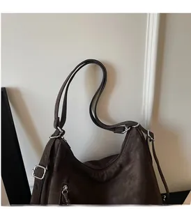 Detail of vintage dark brown leather tote bag showing soft texture and silver buckle accents
