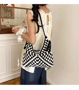 Macro shot of hand-woven crochet tote bag featuring black and white checkerboard pattern