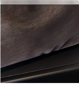 Close-up of the lychee grain leather texture and brand logo on this stylish black tote bag