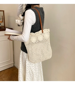 Détail du motif au crochet floral et de la bandoulière en cuir sur ce sac cabas beige