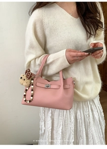 Sac à main rose grainé avec fermoir métal, breloque chien et style rétro minimaliste