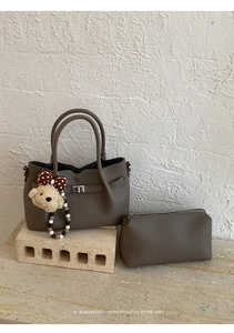 Détail d'un ensemble de sacs taupe avec grain de litchi et breloque ours en peluche