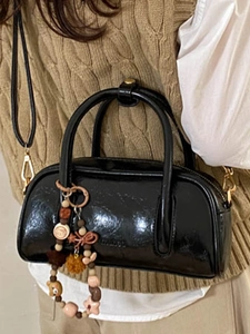 Fashionable black glossy Boston handbag with colorful beaded charm and crossbody strap