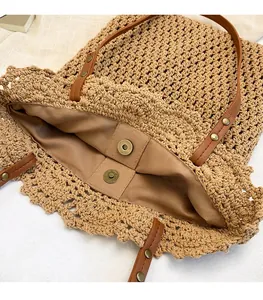 Détail d'un sac cabas en paille tissée avec boucle magnétique et doublure en tissu brun