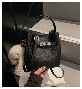 Detail of black pebbled leather bucket bag with silver twist lock and cute bunny charm