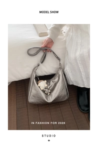 Detail of silver textured PU leather tote bag with stylish plush pendant and adjustable strap