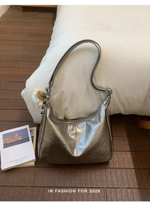 Detail view of silver pleated hobo bag with a soft white plush sheep charm pendant