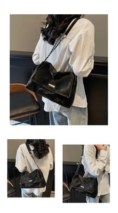 Détail d'un sac cabas élégant en velours noir avec bandoulière chaîne argentée et plaque logo