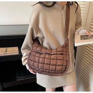 Dettaglio della trama in nylon trapuntato marrone e cuciture della borsa a mezzaluna