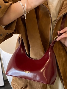 Elegante bolso hobo de cuero brillante burdeos con detalles refinados en la correa