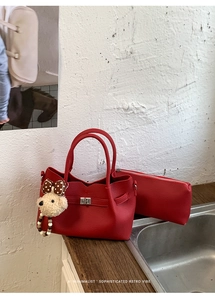 Détail du cabas rouge avec pochette assortie et breloque ours en peluche à nœud à pois marron