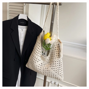 Detailed macro view of beige crochet tote bag featuring bohemian hollow knit patterns
