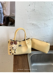 Vue détaillée du sac seau jaune grainé avec charm ours en perles et nœud décoratif