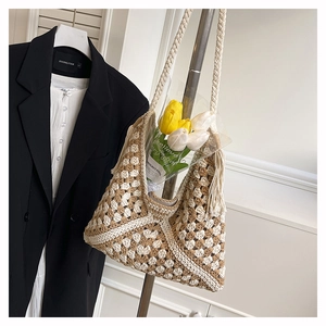 Detail of hand-crocheted tote bag featuring hollow diamond patterns and tassel charm