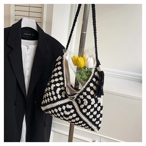 Detailed close-up of handmade crochet tote bag with black and white granny square pattern