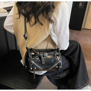 Detailansicht von schwarzen Nieten und Metall-Reißverschlüssen an der Zylindertasche