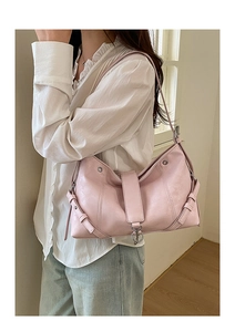 Gros plan détaillé d'un sac à bandoulière rose avec boucles argentées en similicuir