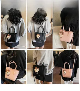 Détails du sac seau avec charm ours en peluche montrant les styles portés main et croisé