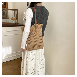 Gros plan du sac fourre-tout en paille tissé avec dentelle au crochet et fines bandoulières