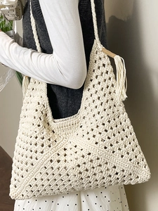 Elegant off-white woven crochet tote bag with geometric patterns and tassel charm detail