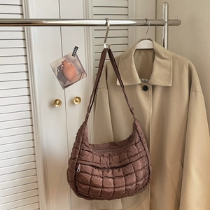 Dettaglio della borsa hobo trapuntata marrone con tasca zip in un ambiente moderno