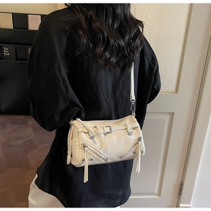 Detailansicht der cremeweißen Zylindertasche aus Kunstleder mit Reißverschlüssen und Nieten