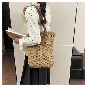 Détail du sac cabas tissé ajouré avec bandoulière en cuir marron et texture tricotée main