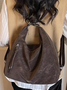 Retro large capacity dark brown soft leather tote bag worn as a shoulder backpack