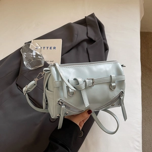 Detailansicht der minzgrünen Lackleder-Zylindertasche mit Metallnieten und Reißverschlüssen