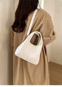 Detail view of white lychee pattern leather bucket bag with elegant gold hardware