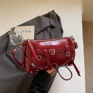 Detailansicht einer roten Lackleder-Zylindertasche mit Nieten und Quasten-Reißverschluss