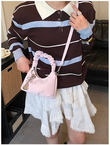 Detailed view of pink pleated handbag featuring star embroidery and heart lock charm