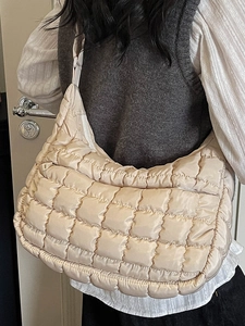 Elegante borsa hobo beige trapuntata con design puffer da donna sulla spalla