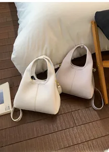 Close-up of litchi grain leather bucket bags in white and lilac with golden hardware