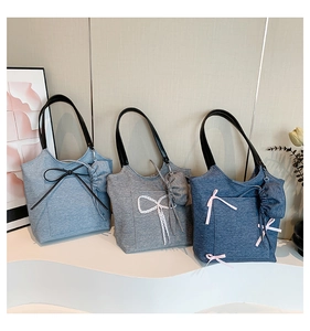 Detail view of denim tote bags with lace bows and matching mini drawstring charms