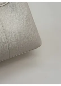 Close-up of white lychee pattern leather bucket bag showing fine stitching detail