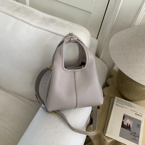 Detail of the litchi pattern leather texture and golden hardware on this bucket bag
