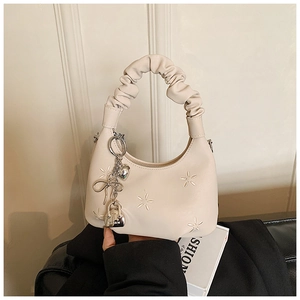 Detailed view of cream moon bag featuring star embroidery and metallic charms