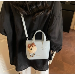 Light blue lychee pattern mini bag with logo and cute teddy bear charm on model back view