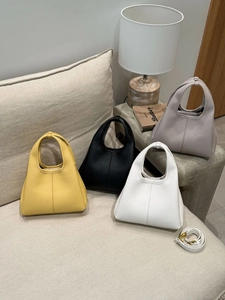 Close-up of litchi grain leather bucket bags in four colors on a modern sofa