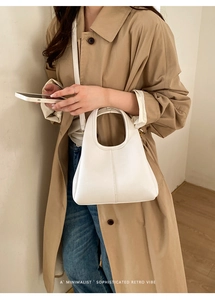 Detailed close-up of white lychee pattern leather on a minimalist bucket handbag