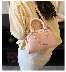 Nahaufnahme der hellrosa Handtasche mit süßer Plüsch-Pony-Stickerei und Details
