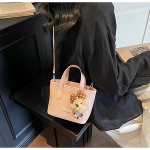 Pink lychee leather bucket bag with teddy bear pendant and detachable shoulder strap