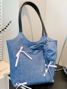 Blue denim tote bag with pink ribbon bows and black handles in Y2K aesthetic style