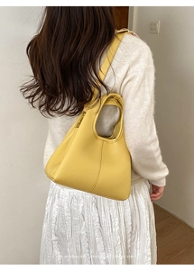 Yellow leather bucket bag shown on model for daily minimalist sophisticated styling