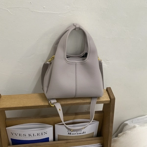 Detailed macro view of light purple lychee grain leather texture and stitching on the tote