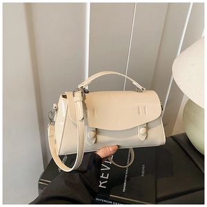 Detail view of cream white minimalist square bag with vintage buckles and fine stitching