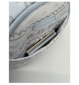 Detailed view of grey suede front pocket with wave pattern and blue leather piping trim